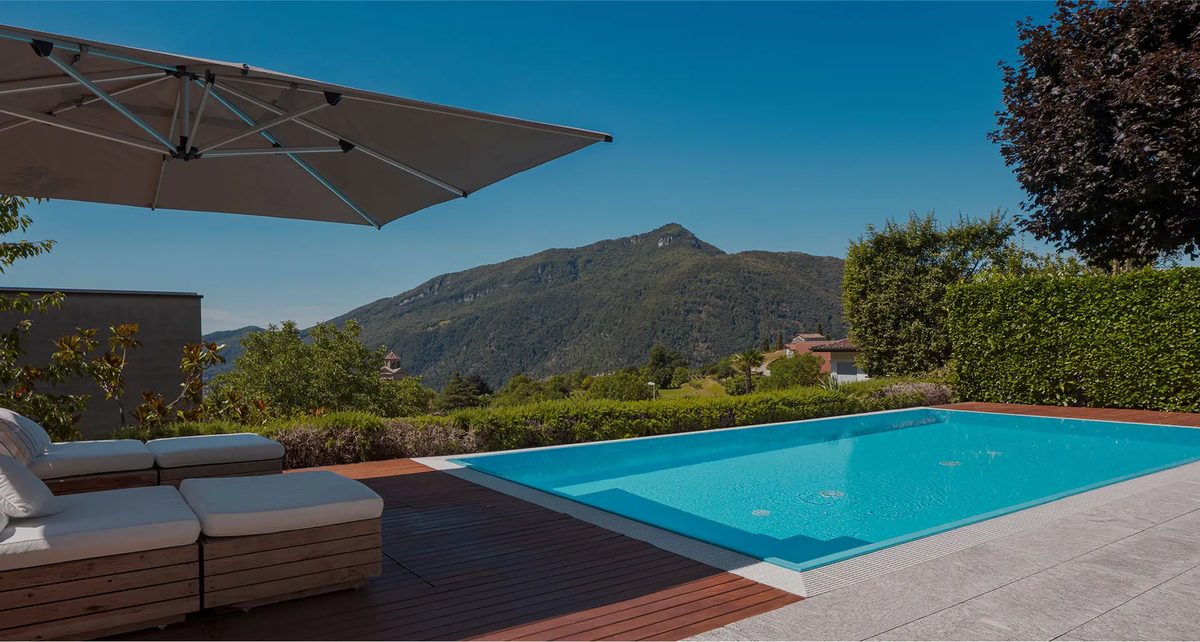 Piscine à débordement face aux montagnes, bordée de transats