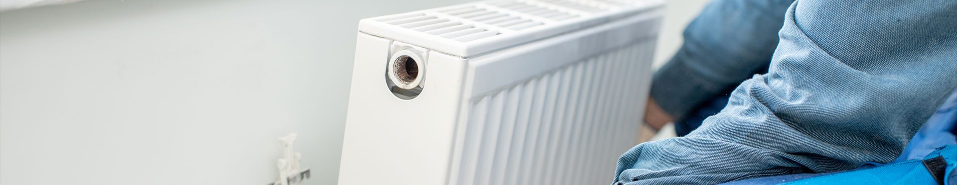 Technicien CLIMAT D intervenant sur un radiateur