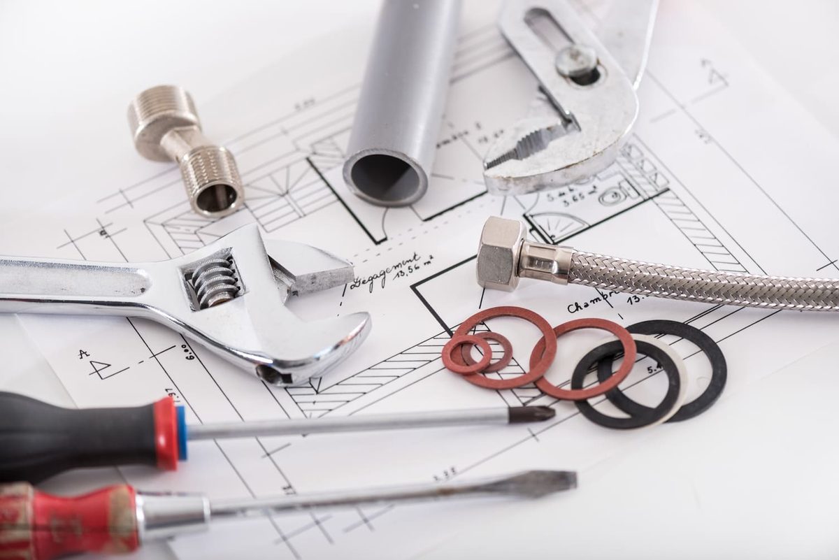 Outils de plombier et raccords posés sur des plans d'installation