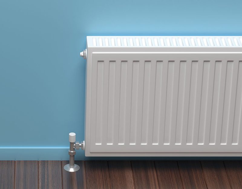 Radiateur blanc installé contre un mur bleu